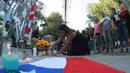 Seorang pendukung mantan Presiden Chile Sebastian Pinera meletakkan bunga di tugu peringatan untuk mengenangnya di luar rumahnya di Santiago pada tanggal 6 Februari 2024. (RAUL BRAVO/AFP)