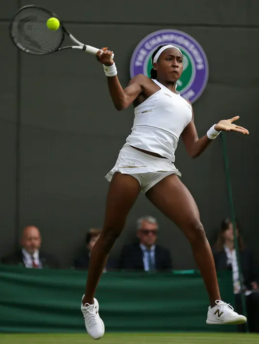 Petenis Cori Gauff berusaha mengembalikan bola pukulan Venus Williams selama pertandingan babak pertama Grand Slam Wimbledon di All England Lawn Tennis and Croquet Club, London (1/7/2019). Cori merupakan petenis AS berusia 15 tahun yang berhasil mengalahkan Venus Williams. (AP Photo/Tim Ireland)