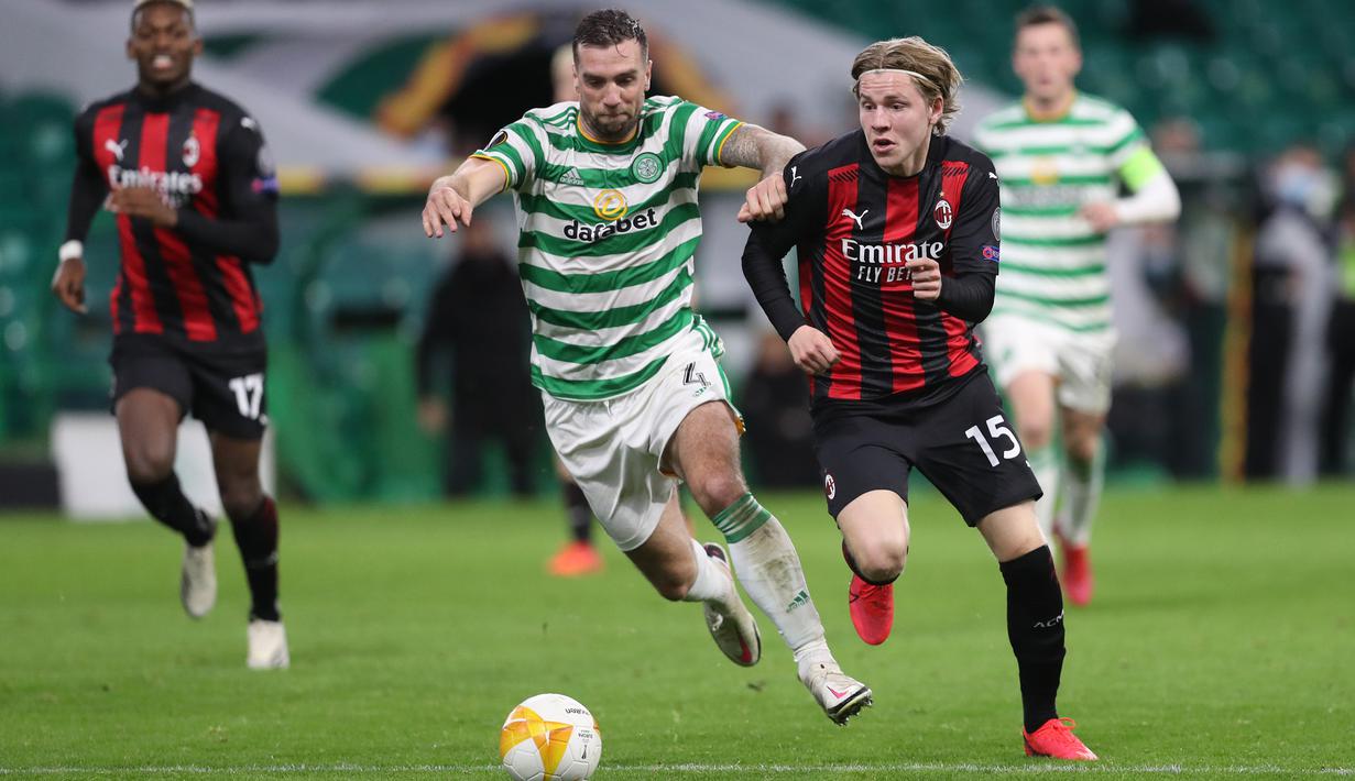 Gelandang AC Milan, Jens Petter Hauge, Berebut bola dengan bek Celtic, Jack Hendry, pada laga Grup H Liga Europa 2020/2021 di Celtic Park Stadion, Jumat (23/10/2020). AC Milan menang 3-1 atas Celtic. (AFP/Russell Cheyne/pool)