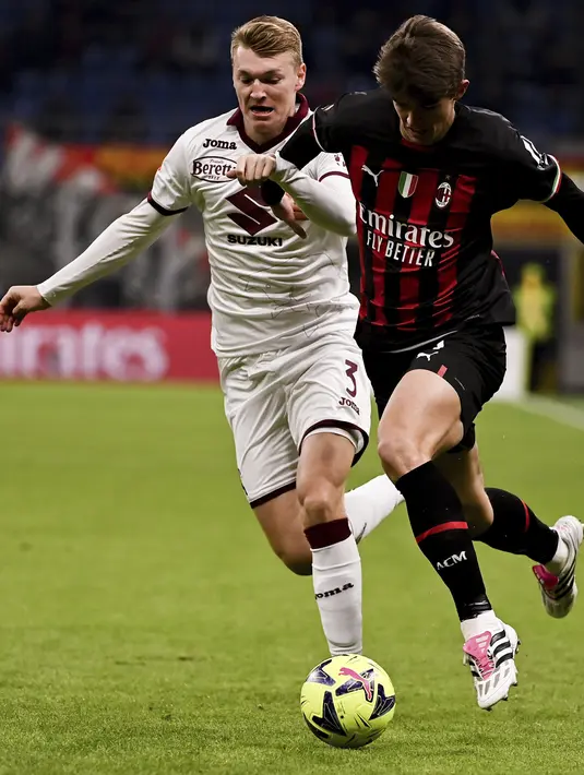 <p>Penyerang AC Milam, Charles De Ketelaere membawa bola dari kawalan pemain Torino, Perr Schuurs pada babak 16 besar Coppa Italia di Stadion San Siro di Milan, Italia, Kamis (12/1/2023). Torino menang tipis atas AC Milan dengan skor 1-0 berkat gol Michel Adopo di perpanjangan waktu. (Marco Alpozzi/LaPresse via AP)</p>