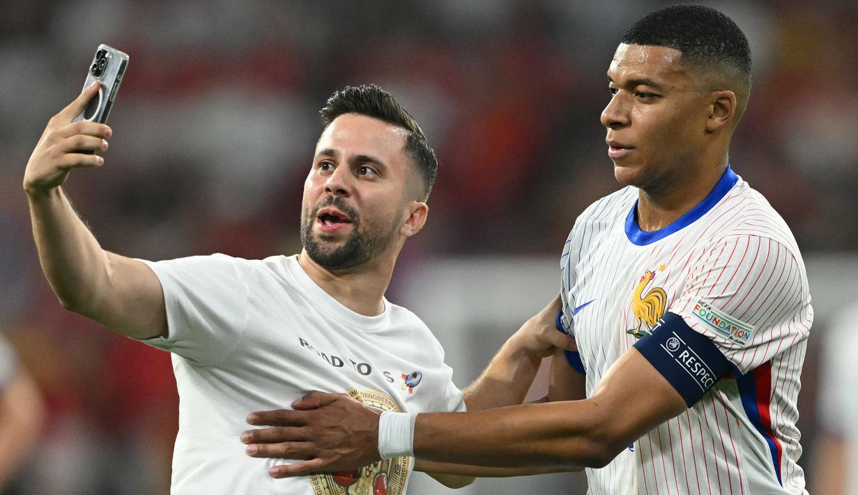 Dia berlari ke arah Mbappe dengan keinginan yang jelas untuk berfoto selfie dengan pemain baru Real Madrid tersebut. (Fabrice COFFRINI / AFP)