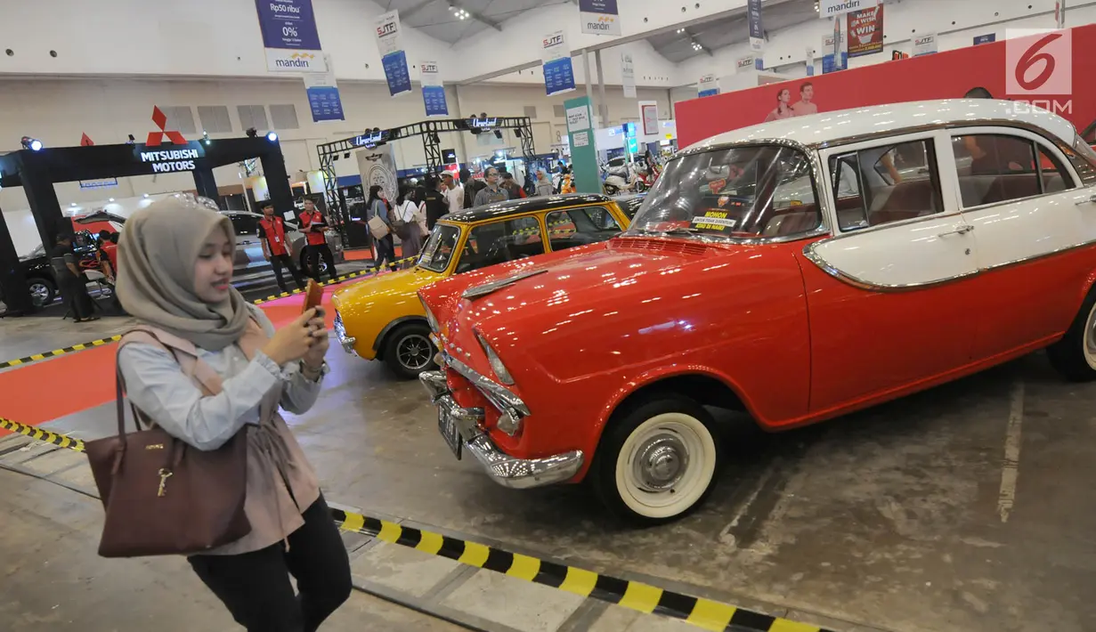 Pengunjung melewati booth industri otomotif saat Pekan Raya Indonesia 2018 di ICE BSD City, Tangerang, Kamis (4/10). Untuk berkunjung ke PRI 2018 dikenakan biaya tiket Rp 35 ribu saat akhir pekan dan Rp 25 ribu saat hari kerja. (Merdeka.com/Arie Basuki)