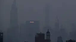 Bangunan Met Life dan Chrysler bersinar melalui kabut tebal yang menggantung di langit Manhattan, New York, Selasa (20/7/2021). Lebih dari 60 kebakaran hutan melanda sekitar 10 negara bagian di barat Amerika Serikat (AS), menyebabkan langit berkabut hingga New York.  (AP Photo/Julie Jacobson)