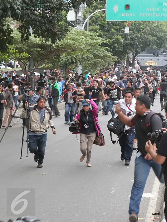 Dua orang jurnalis terlihat panik usai mendengar isu bom yang akan kembali meledak pasca terjadinya ledakan yang terjadi di Pos polisi dekat pusat perbelanjaan Sarinah, Jalan Thamrin, Jakarta, Kamis (14/1). (Liputan6.com/Angga Yuniar)