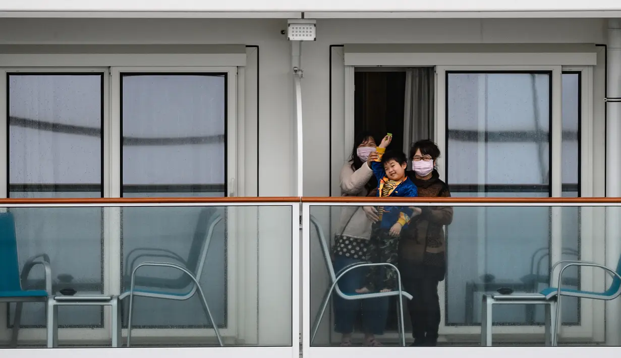 <p>Penumpang melambaikan tangan ke arah media dari kapal pesiar World Dream yang berlabuh di Kai Tak Cruise Terminal, Hong Kong, Rabu (5/2/2020). Hong Kong mengarantina lebih dari 1.800 orang di atas kapal pesiar yang berpaling dari pelabuhan Taiwan tersebut terkait wabah virus corona. (AP Photo/ Vince</p>