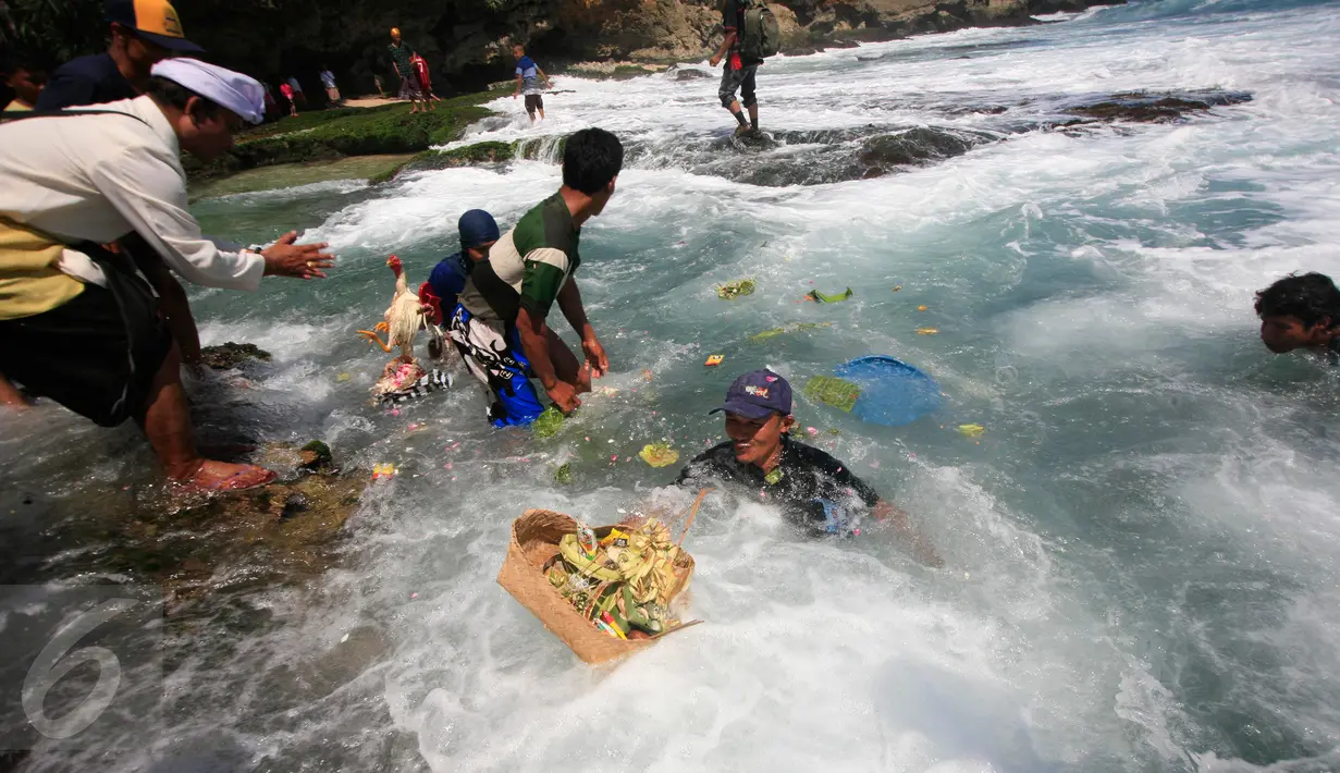 Sejumlah warga berebut perlengkapan upacara Melasti yang di larung di Pantai Ngobaran ,Gunung Kidul,Yogyakarta, (22/2).Melasti merupakan upacara mensucikan diri menyambut perayaan tahun baru Nyepi.(Boy Harjanto)