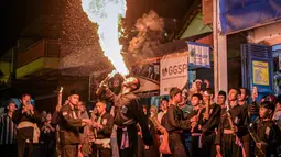 Seorang pemuda Muslim Indonesia melakukan aksi menghembuskan api saat parade yang menandai dimulainya tahun baru Islam di Surabaya, Jawa Timur pada Kamis 26 Juni 2025 malam. (Juni KRISWANTO/AFP)