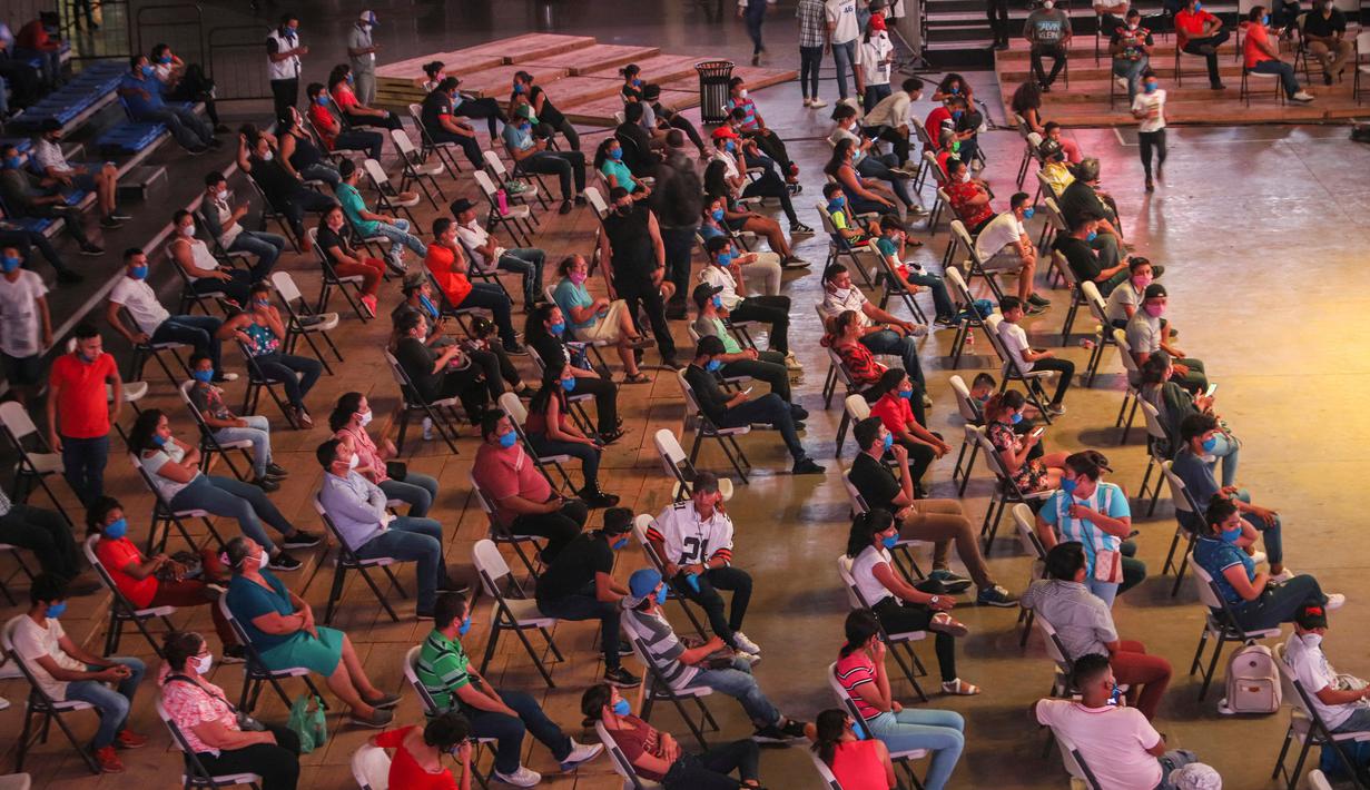 Penonton menerapkan jaga jarak saat melihat pertandingan tinju yang dipromotori oleh mantan juara dunia Rosendo Alvarez di Managua, Nikaragua pada 25 April 2020. Nikaragua merupakan salah satu dari sedikit negara yang kegiatan olahraga tetap berjalan di tengah pandemi Covid-19. (AP/Alfredo Zuniga)