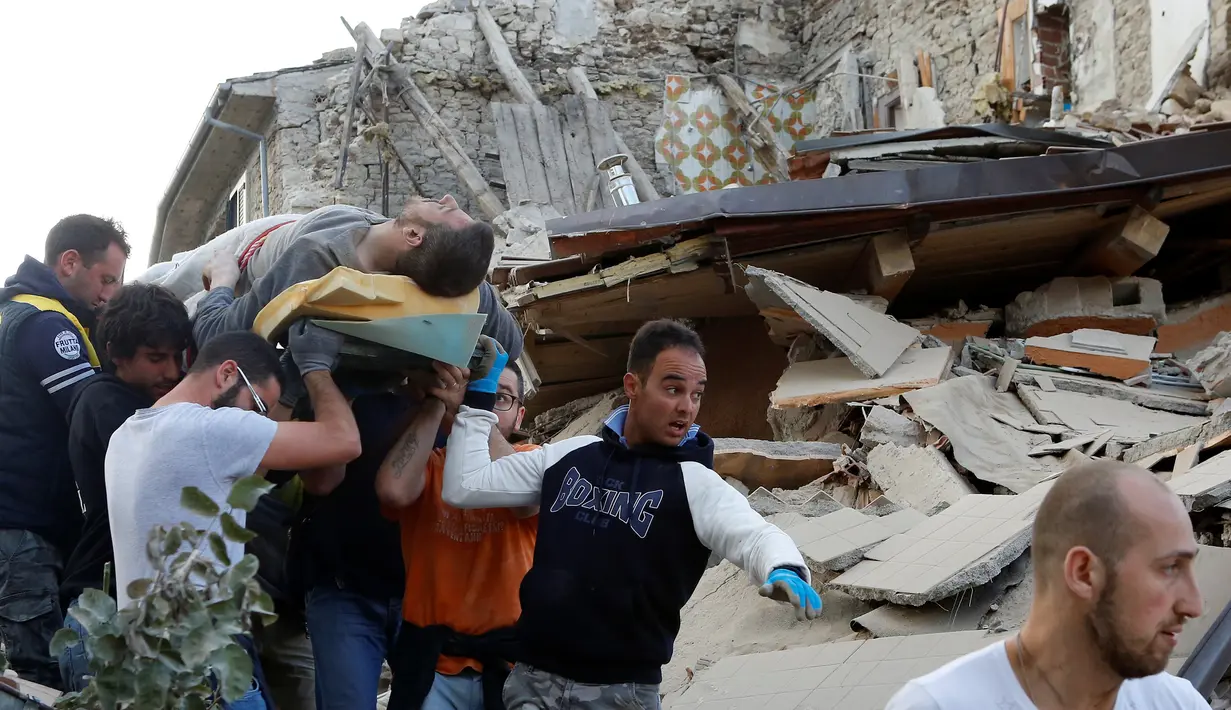Seorang pria dengan keadan hidup dibawa usai tertimbun reruntuhan akibat gempa dahsyat menghantam kota Amatrice, Italia tengah, (24/8). Gempa menyebabkan kerusakan besar dan getarannya membuat panik penduduk yang sedang tertidur. (REUTERS/Remo Casilli) 