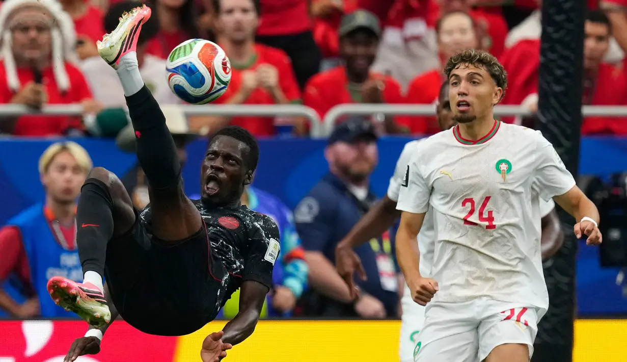 Pemain Kanada Tani Oluwaseyi mencoba tendangan salto ke gawang di depan pemain Maroko Neil El Aynaoui selama pertandingan sepak bola babak 16 besar Piala Dunia antara Kanada dan Maroko di Houston, Sabtu (04/07/2026). (AP/ /The Canadian Press / Frank Gunn)