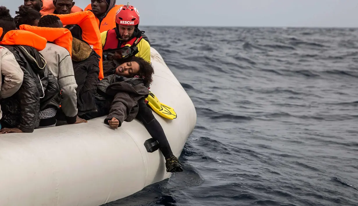 Seorang wanita saat diselamatkan petugas dari LSM Spanyol Proactiva Open Arms, setelah meninggalkan Libya yang mencoba mencapai tanah Eropa di atas sebuah kapal karet yang penuh sesak, 60 mil sebelah utara Al-Khums, Libya (18/2). (AP Photo/Olmo Calvo)