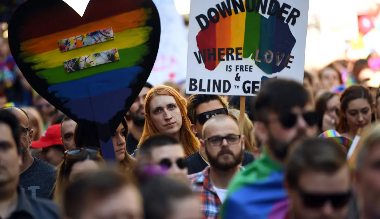 Sejumlah pendemo membawa poster saat menggelar demo kesetaraan pernikahan sejenis di Sydney (10/9). Mereka turun kejalan untuk meminta kesetaraan pernikahan pasangan sesama jenis di Sydney. (AFP Photo/Saeed Khan)