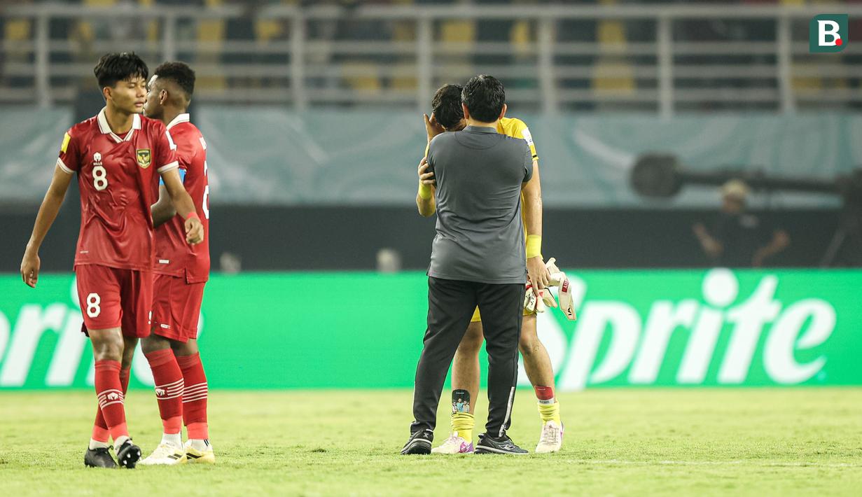 Pelatih Timnas Indonesia U-17, Bima Sakti memberi selamat kepada sang kiper, Ikram Algiffari setelah berakhirnya laga menghadapi Timnas Ekuador U-17 pada laga pertama Grup A Piala Dunia U-17 2023 di Stadion Gelora Bung Tomo, Surabaya, Jumat (10/11/2023). (Bola.com/Bagaskara Lazuardi)