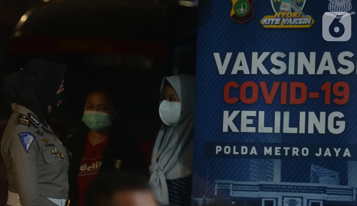 Polisi berbincang dengan warga saat Vaksinasi Covid-19 keliling di Kawasan Bulungan, Jakarta, Kamis (24/6/2021). Polda Metro Jaya membuka layanan vaksinasi Covid secara massal dengan berkeliling di Kawasan Bulungan, Jakarta, Kamis (24/6/2021). Malam. (merdeka.com/Imam Buhori)