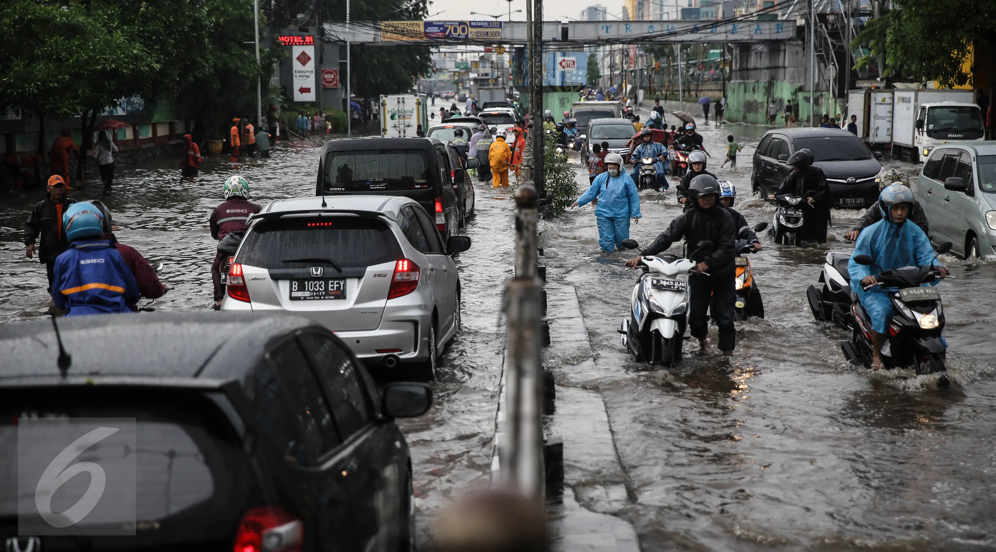 Warga mendorong sepeda motornya saat menerobos banjir di jalan depan Ancol, Jakarta, Kamis (21/4). Hujan deras yang mengguyur sejak semalam menyebabkan beberapa kawasan di Jakarta tergenang banjir. (Liputan6.com/Faizal Fanani)