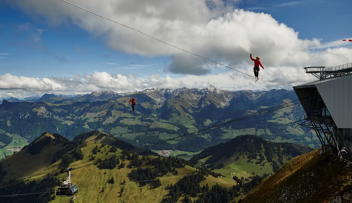 Tijmen Van Dieren dari Belanda (kanan) berjalan diatas tali saat acara Highline Extreme di puncak Moleson, Swiss (15/9). Perlombaan berjalan di seutas tali diatas ketinggian ini diikuti oleh lima puluh slackliner terbaik Dunia.(AFP Photo/Michael Buholzer)