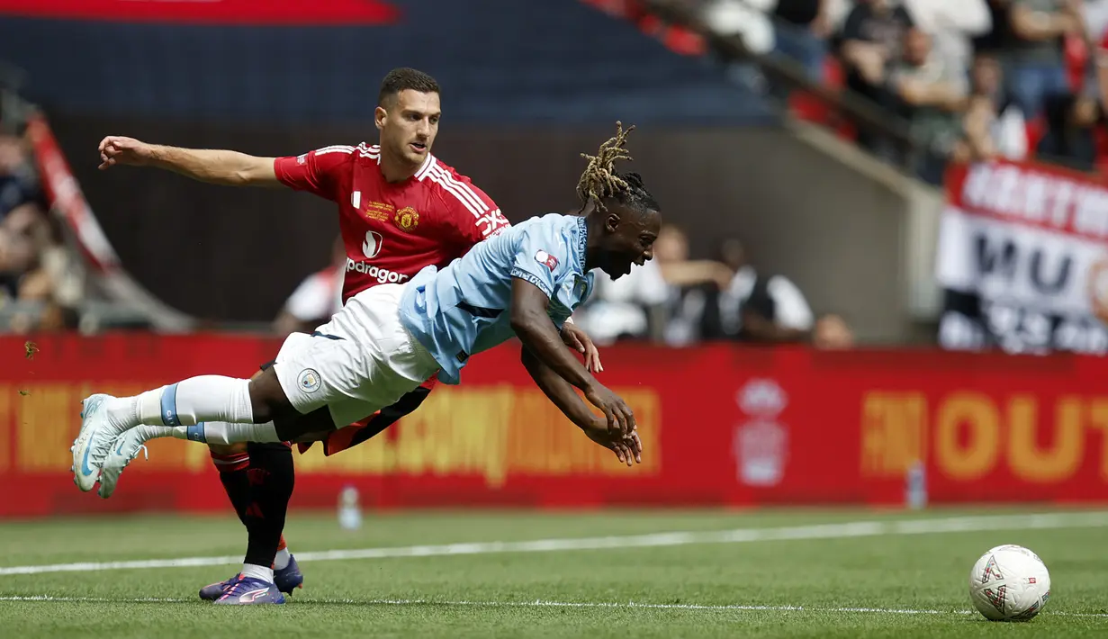 Gelandang Manchester City, Jeremy Doku (kanan) terjatuh saat perebutan bola dengan bek Manchester United, Diogo Dalot pada laga Community Shield 2024 di Wembley Stadium, London, Sabtu (10/8/2024). (AP Photo/David Cliff)