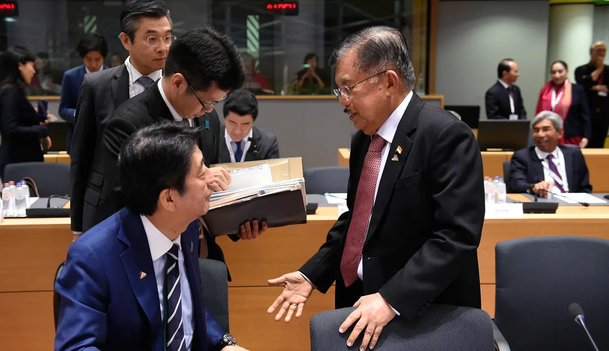 Wakil Presiden Indonesia, Jusuf Kalla berbincang dengan PM Jepang Shinzo Abe selama pertemuan KTT ASEM ke-12 di Brussels, Belgia, (18/10). KTT ASEM ke-12 mengangkat tema Europe and Asia: Global Partners for Global Challenges. (AFP Photo/John Thys)