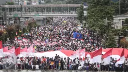Ribuan warga berkumpul di Bundaran HI, Jakarta untuk memeriahkan aksi damai 'Kita Indonesia', Minggu (4/12). Ada banyak bendera Merah Putih dikibarkan oleh para peserta aksi hingga membuat Bundaran HI tampak memerah. (Liputan6.com/Fery Pradolo)