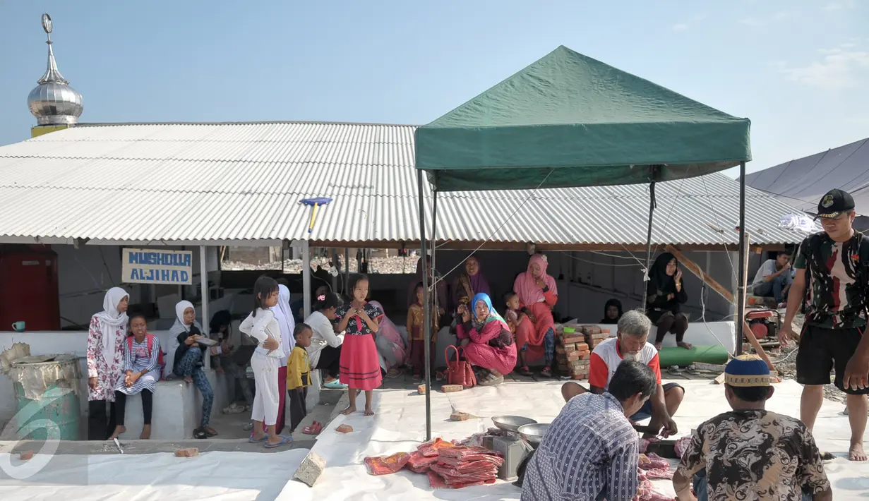 Warga menyaksikan panitia saat memotong daging hewan kurban di kawasan Kampung Akuarium, Jakarta, Senin (12/9). Warga korban gusuran Kampung Akuarium Pasar Ikan merayakan Idul Adha 1437 H di antara reruntuhan rumah mereka. (Liputan6.com/Yoppy Renato)