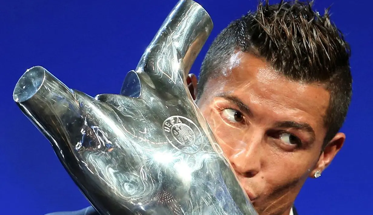 Cristiano Ronaldo mencium trofi Pemain Terbaik Eropa 2016 yang dianugerahkan kepadanya saat acara pengundian grup Liga Champions di Grimaldi, Monako, 25/8/2016).(Reuters/Eric Gaillard)