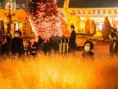 Warga mengunjungi Kuil Jogyesa pada malam sebelum para siswa mengikuti ujian masuk universitas atau suneung di Seoul, Korea Selatan, 17 November 2021. Lebih dari setengah juta siswa akan mengikuti suneung di Korea Selatan. (Anthony WALLACE/AFP)