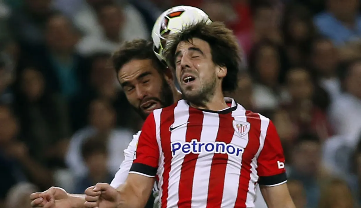 Bek Real Madrid, Daniel Carvajal, berebut bola dengan gelandang Athletic Bilbao, Benat Etxebarria di lanjutan La Liga Spanyol di Stadion Santiago Bernabeu, (6/10/2014). Real Madrid unggul telak 5-0 atas Athletic Bilbao. (REUTERS/Sergio Perez)