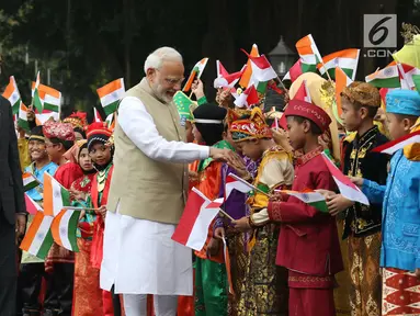 Perdana Menteri (PM) India, Narendra Modi didampingi Presiden Joko Widodo (Jokowi) bersalaman dengan murid Sekolah Dasar berpakaian adat Indonesia dalam upacara penyambutan di Istana Merdeka, Jakarta, Rabu (30/5). (Liputan6.com/Angga Yuniar)
