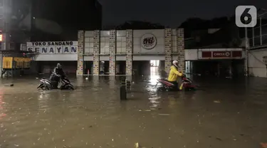 Warga mendorong motor saat terjebak banjir di Jalan Kemang Raya, Jakarta Selatan, Selasa (4/10/2022). Hujan yang mengguyur wilayah Ibu Kota Jakarta mengakibatkan banjir menggenangi kawasan Kemang, Jakarta. (Liputan6.com/Johan Tallo)