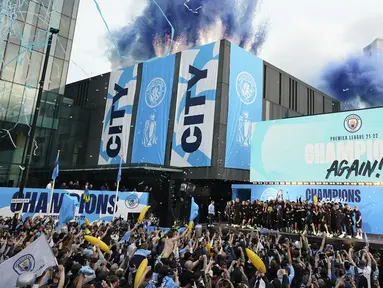 Suar dan pita dilepaskan saat para pemain Manchester City merayakan kemenangan Liga Inggris di atas panggung selama parade kemenangan di Manchester, Inggris, 23 Mei 2022. (AP Photo/Jon Super)