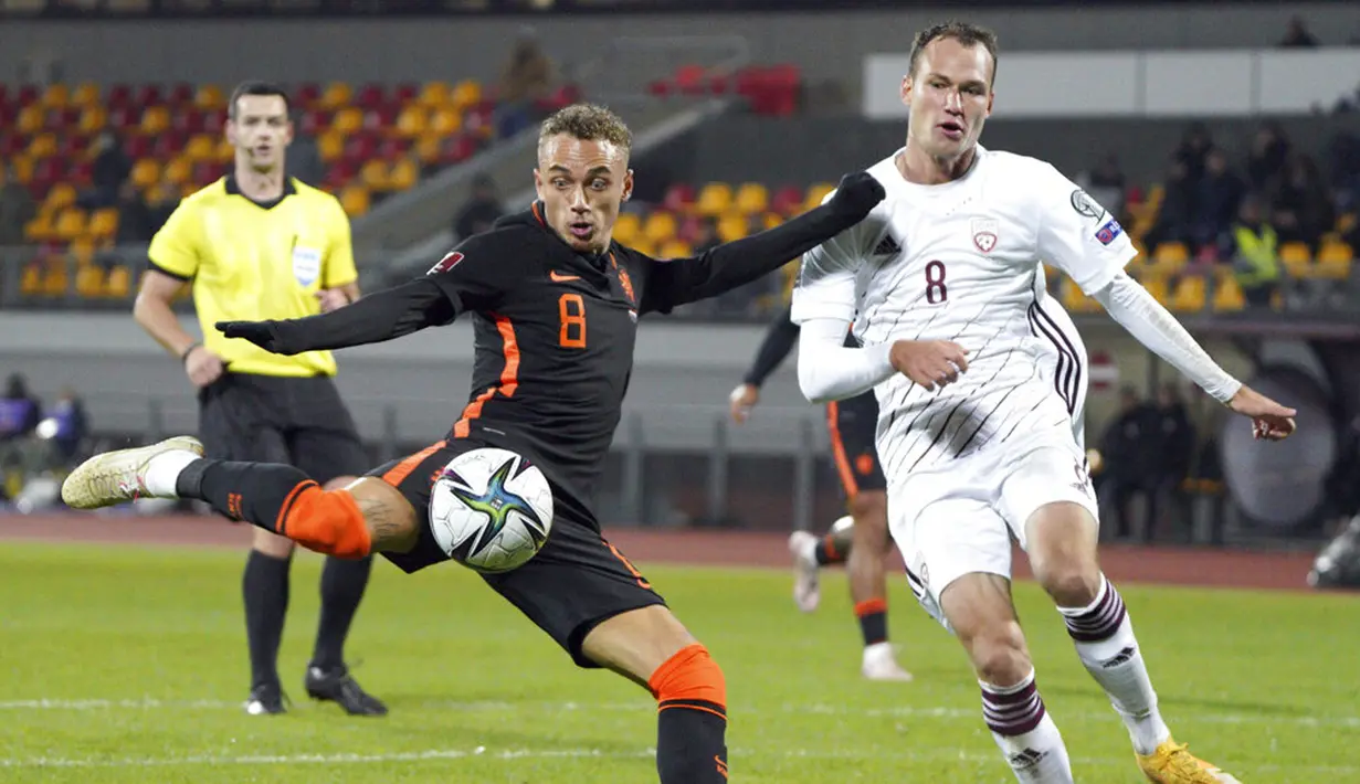 Pemain Latvia Eduards Emsis (kanan) berebut bola dengan pemain Belanda Noa Lang (kiri) pada pertandingan sepak bola kualifikasi Grup G Piala Dunia 2022 di Stadion Daugava, Riga, Latvia, 8 Oktober 2021. Belanda menang 1-0. (AP Photo/Roman Koksarov)