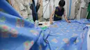 Pelaku UMKM binaan Dinas Koperasi, menyelesaikan produksi seragam sekolah di kawasan PIK Pulogadung, Jakarta, Jumat (3/7/2026). Permintaan seragam meningkat hingga kapasitas produksi mencapai 1.000 potong untuk berbagai pesanan. (Kapanlagi.com/Budy Santoso)