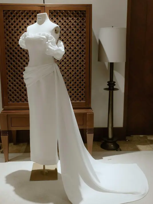 Gaun tersebut memiliki potingan off-the-shoulder dengan ruffle dan train yang melilit di pinggang dengan draping seperti sabuk [IG @auroramanda95]