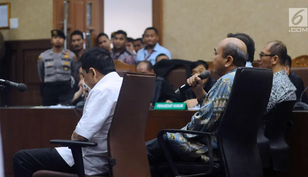 Terdakwa korupsi proyek E-KTP Setya Novanto (kiri) tertunduk saat tim dokter membacakan hasil pemeriksaan kesehatan pada lanjutan sidang perdana, Pengadilan Tipikor, Jakarta, Rabu (13/12). Setya Novanto dinyatakan sehat. (Liputan6.com/Helmi Fithriansyah)