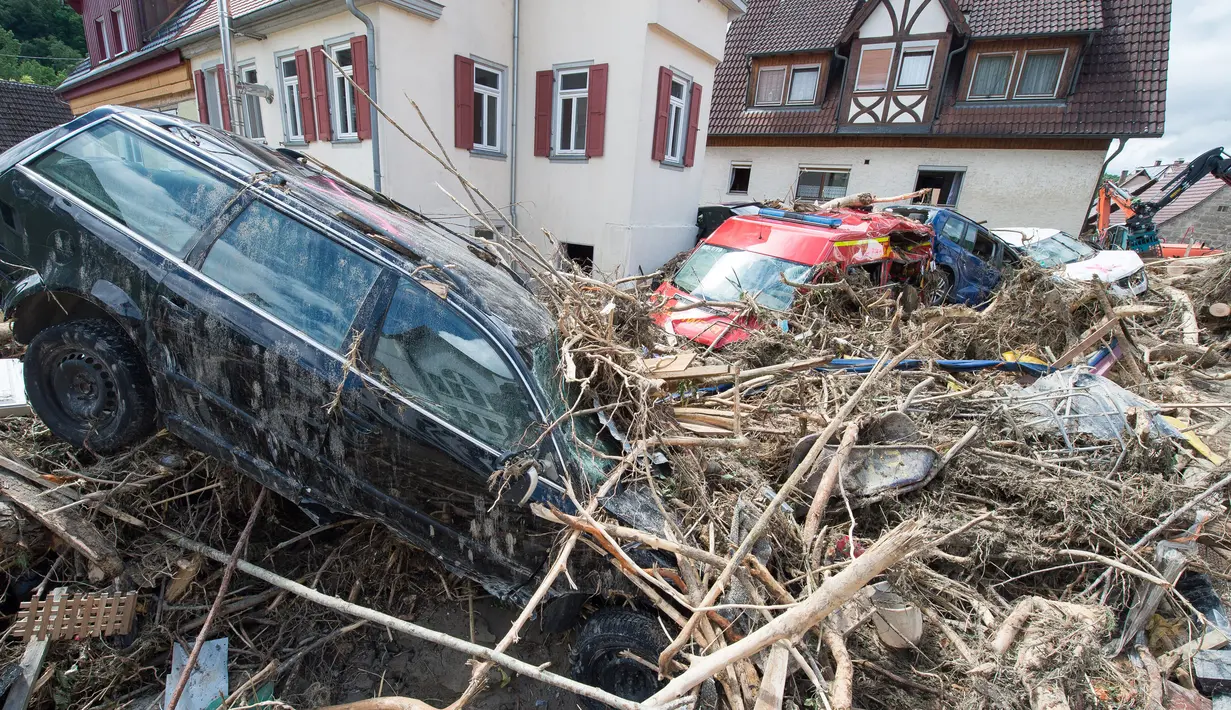 Mobil yang rusak disertai tumpukan ranting pohon yang terbawa oleh aliran arus banjir yang melanda wilayah Braunsbach, Jerman selatan (30/5). Empat orang tewas dan beberapa lainnya luka-luka dalam musibah ini. (Marijan Murat / dpa / AFP)