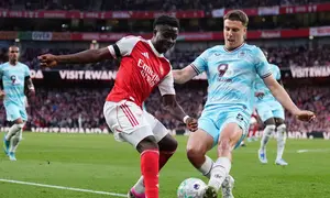 Pemain Arsenal, Bukayo Saka, berebut bola dengan pemain Burnley, Maxime Esteve, dalam pertandingan Liga Inggris di London, Inggris, Selasa (19/5/2026) dini hari WIB. (John Walton/PA via AP)
