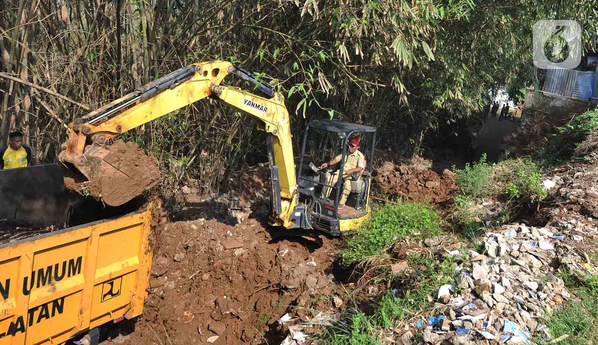 Petugas menggunakan alat berat backhoe membersihan jalan dari longsoran tanah di RT 04/RW 03, Kademangan, Keranggan, Setu, Tangerang Selatan, Banten, Selasa (3/12/2019). Longsor pada Senin sore kemarin menewaskan seorang pengendara sepeda motor yang melintas, Anggi (23). (merdeka.com/Arie Basuki)