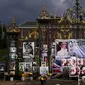 Seorang wanita berdiri di antara bunga dan pesan peringatan untuk Putri Diana yang dipajang di gerbang Istana Kensington, London, Rabu (31/8/2022). Hari ini menandai peringatan 25 tahun kematian Putri Diana dalam kecelakaan mobil di Paris. (AP Photo/Alastair Grant)