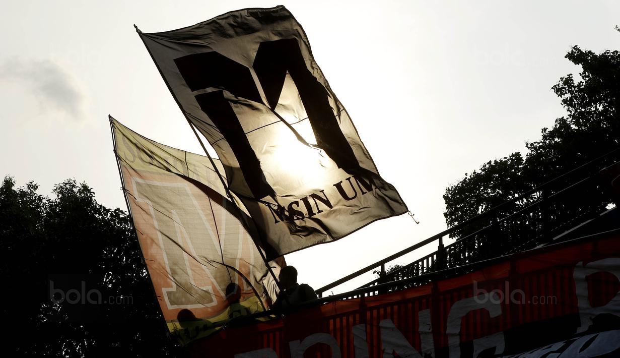 Suporter Universitas Negeri Malang (UM) mengibarkan bendera saat melawan Politeknik Negeri Malang (Polinema) pada laga Torabika Campus Cup 2017 di Stadion UM, Malang, Rabu, (01/11/2017). UM menang 2-0 atas Polinema. (Bola.com/M Iqbal Ichsan)