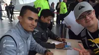 Pebalap Manor Racing, Pascal Wehrlein dan Rio Haryanto, memberikan tanda tangan kepada fans. (Bola.com/Twitter/Manor Racing)
