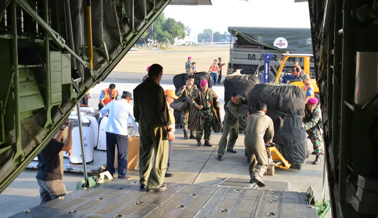 Satgas Pasukan Reaksi Cepat Penanggulangan Bencana (PRCPB) Marinir memasukkan logistik bantuan ke dalam pesawat angkut C-130 Hercules TNI Angkatan Udara menuju Lombok dari Lanud Halim Perdanakusuma, Jakarta, Senin (6/8). (Liputan6.com/HO/Dispen Kormar)Sat