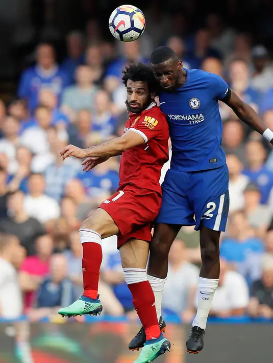 Penyerang Liverpool, Mohamed Salah berebut bola udara dengan pemain Chelsea Antonio Ruediger selama pertandingan lanjutan Liga Inggris di Stamford Bridge di London (6/5). Chelsea menang tipis atas Liverpool 1-0. (AP Photo/Kirsty Wigglesworth)
