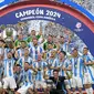 Penyerang Argentina, Lionel Messi (tengah) mengangkat trofi saat merayakan kemenangan usai final turnamen Copa America 2024 melawan Kolombia di Stadion Hard Rock, Miami, Florida pada 14 Juli 2024 atau Senin 15 Juli 2024 WIB. (JUAN MABROMATA/AFP)