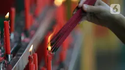 Umat Buddha membakar dupa sesaat sebelum ritual sembahyang di Vihara Buddha Dharma dan 8 Pho Sat, Kabupaten Bogor, Jawa Barat, Rabu (26/5/2021). Umat Buddha melakukan sembahyang peringatan Hari Raya Waisak di Vihara Buddha Dharma dan 8 Pho Sat  (Liputan6.com/Helmi Fithriansyah)