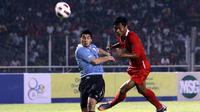 Luiz Suarez berebut bola dengan pemain Indonesia, Yongki Ariwibowo saat pertandingan Indonesia vs Uruguay di Senayan,Jakarta(8/8). Indonesia kalah 1-7. (Bola.com/Nicklas Hanoatubun)