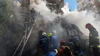Petugas pemadam kebakaran bekerja setelah sebuah pesawat tak berawak menghantam gedung-gedung di Kyiv, Ukraina, Senin (17/10/2022).   Pesawat tak berawak menghantam sejumlah gedung ibu kota Ukraina pada Senin pagi ledakan tesebut menggema di seluruh Kyiv dan menimbulkan kepanikan sehingga orang-orang berlarian ke lokasi yang aman.  (AP Photo/Roman Hrytsyna)