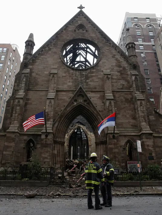 Petugas pemadam kebakaran New York berdiri di depan Gereja Katedral Ortodoks Serbia dari Saint Sava di Manhattan, pasca kebakaran yang terjadi pada Minggu, 1 Mei 2016, beberapa saat setelah umat merayakan Paskah, Senin (2/5). (REUTERS/Brendan McDermid)
