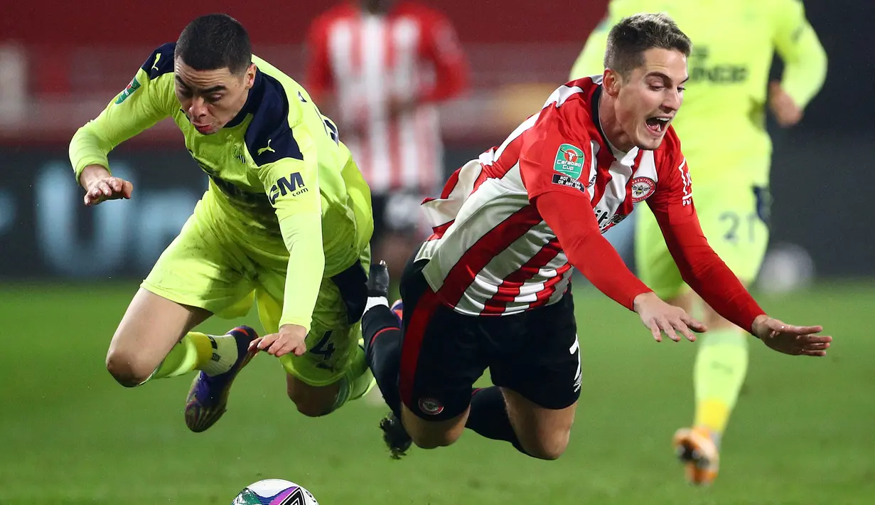 Gelandang Newcastle United, Miguel Almiron (kiri) dan striker Brentford, Sergi Canos, terjatuh usai perebutan bola dalam laga perempatfinal Piala Liga Inggris Carabao Cup di Brentford Community Stadium, Selasa (22/12/2020). Newcastle United kalah 0-1 dari Brentford. (AFP/Hannah McKay/Pool)