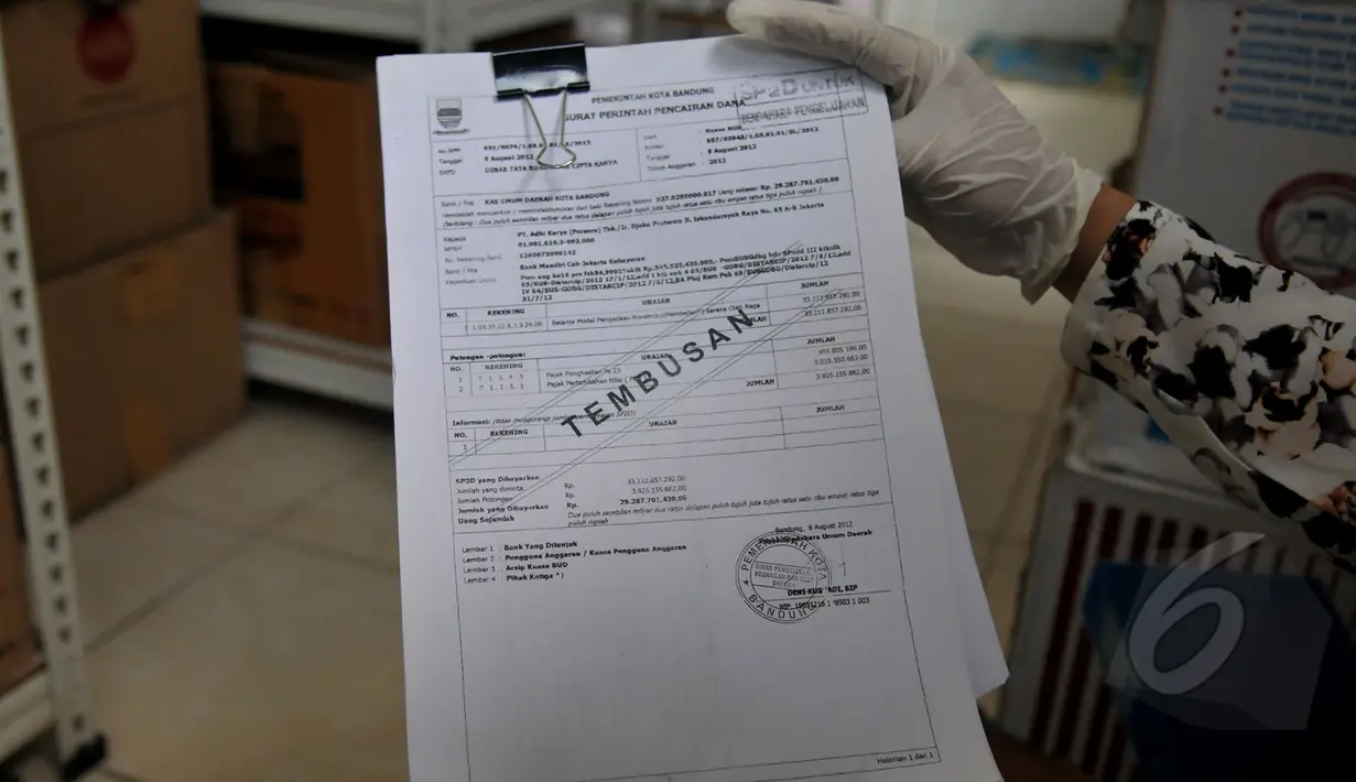 Penyidik Bareskrim memperlihatkan sebuah dokumen saat melakukan penggeledahan di Kantor PT Adhi Karya Pasar Minggu, Jakarta, Rabu (13/5/2015). (Liputan6.com/Johan Tallo) 