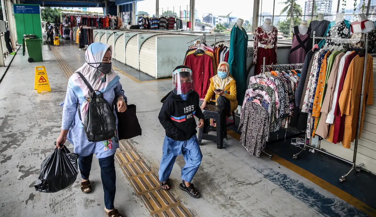 Warga mengenakan masker saat melintas di Jembatan Penyeberangan Multiguna atau Skybridge Tanah Abang, Jakarta, Jumat (19/6/2020). Kendati pusat perbelanjaan telah dibuka sejak 15 Juli 2020, aktivitas jual beli di Skybridge Tanah Abang terpantau sepi. (Liputan6.com/Faizal Fanani)